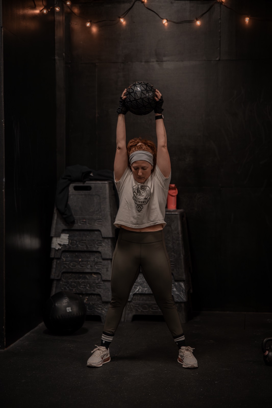 A woman pressing a medicine ball overhead